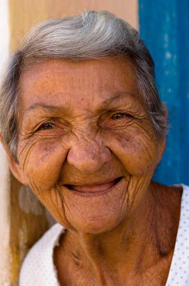 Vibrant elderly woman smiling, portrait of aging gracefully, joyful expression, warm emotion, authentic capture.